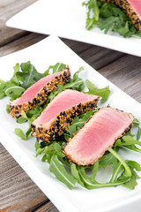 tuna tataki sesame crust appetizer plate over wood backgroung