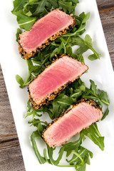 tuna tataki sesame crust appetizer plate over wood backgroung