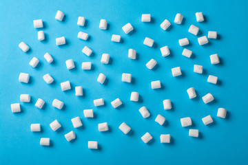 Sweet Marshmallows on blue background with a shadow. Flat lay top view
