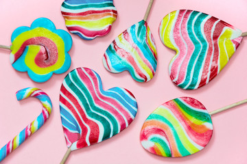 Obraz premium Many colorfull lollipops and candy on pink. Top view.