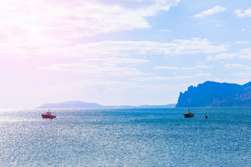 Sea bay and boats in the sea against mountainous background.