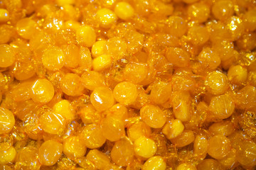 Lollipops yellow background. A lot of sugar candies are poured into a pastry shop.