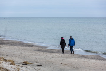 Promenad p&aring; strand vid havet en mulen vinterdag