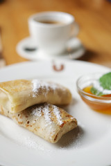 Soft focus photo of pancakes with jam and cup of coffee. Breakfast at a cafe?