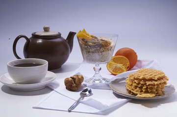 healthy breakfast on white. Oatmeal with yoghurt, figs, banana and orange and waffles