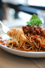 spaghetti Bolognese with minced beef and tomato sauce garnished with parmesan cheese and basil , Italian food