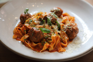Spaghetti pasta with beef meatballs and tomato sauce on wood background . italian food
