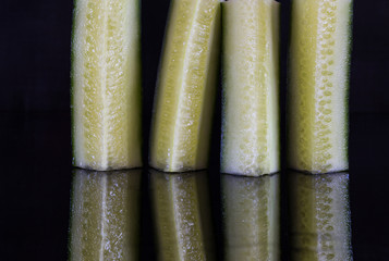 Cut cucumbers black background 8