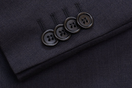 Buttons on the sleeve of a man's jacket. Textile. Background.