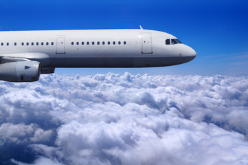 Safe flight of a passenger plane over the clouds, blue sky