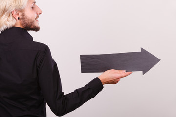 Man holding black arrow pointing right