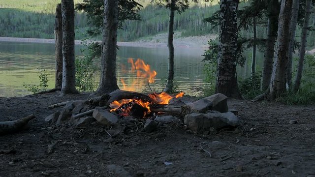 Slow motion campfire near mountain lake.