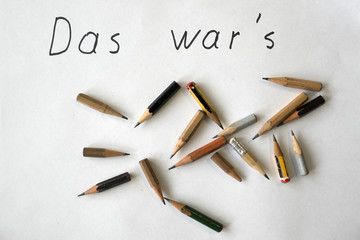 Fototapeta na wymiar Ironic german retirement farewell note 'Das war's' (that's it) with worn pencils on white background