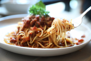 spaghetti Bolognese with minced beef and tomato sauce garnished with parmesan cheese and basil , Italian food