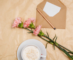 A cup of coffee, flowers and a envelope