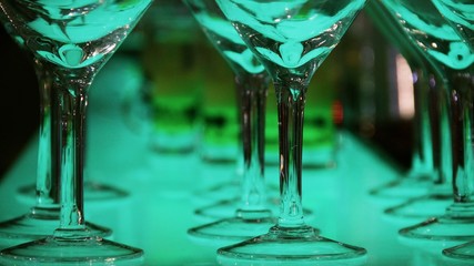Colorful drinks in cocktail glasses glowing on the bar counter 

