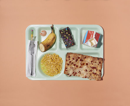 Overhead view of school lunch tray isolated on peach background