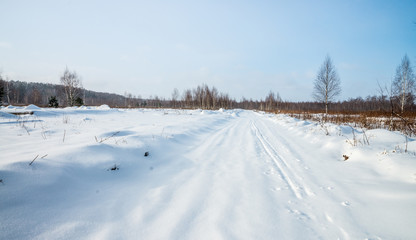 Fototapeta na wymiar A countryside road covered with snow