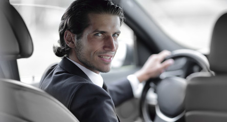 man sitting behind the wheel of a car