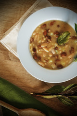 Beans and fregola soup on rustic table
