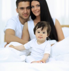 Fototapeta premium Portrait of a joyful family sitting on the bed at home