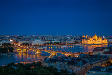 Fototapeta premium Budapest, Hungary - Panoramic skyline view of Budapest at blue hour with the illuminated Parliament of Hungary, Margaret Bridge and Margaret Island