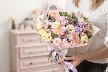 bouquet of delicate pastel color. beautiful luxury bunch of mixed flowers in womans hand. the work of the florist at a flower shop.