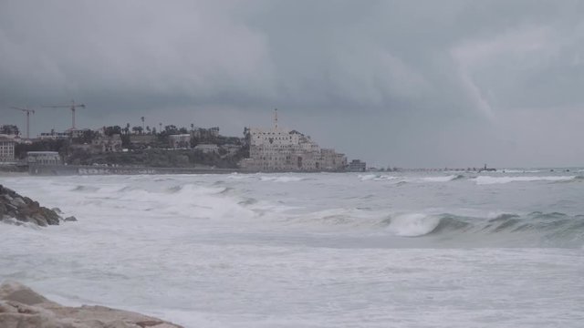 Establishing shot of the Jaffa aka Joppa Mediterranean Waves crash on the coast. Slowmotion clip of the waves crashing onto the beach of Tel Aviv