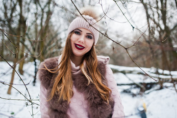 Girl with braces at winter day wear on fur coat and headwear.