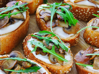 Bruschetta with mushrooms. Bruschetta with arugula and champignons.