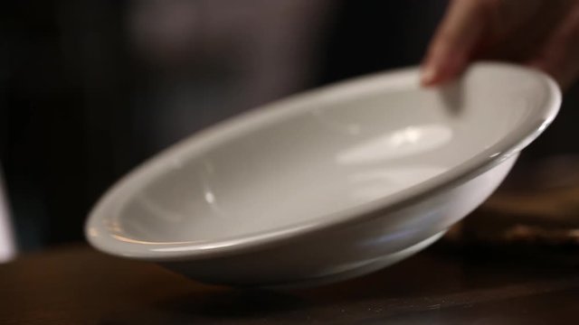 Person lays empty bowl on table