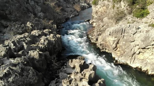 vol en arri&egrave;re et au ralenti au dessus d'une rivi&egrave;re de montagne et ses rapides bleus verts
