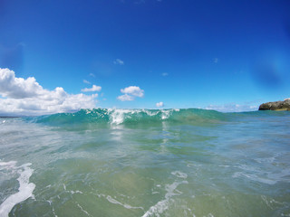 Fish-Eye Lens Photo: A small curling wave from the Atlantic Ocean during a beautiful sunny day at the beach. Sosùa, Dominican Republic.