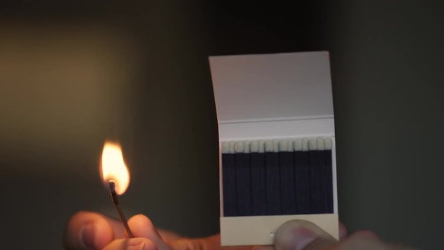 Closeup of a match setting a row of match heads on fire