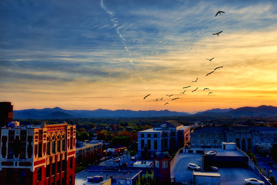 Asheville North Carolina at sunset with the Blue Ridge Mountains in the distance.