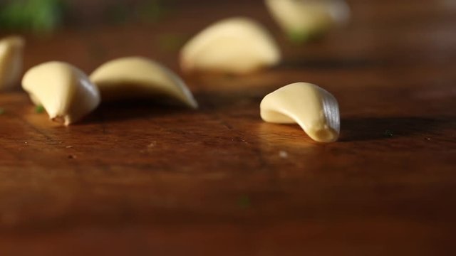 Peeled garlic cloves drop on table, close up