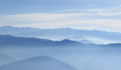 Fototapeta na wymiar Mountain layer in morning sun ray and winter fog