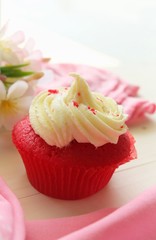 Red velvet cupcake on wooden table.