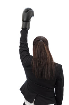 The fight for equal pay and feminism concept with a woman wearing a black boxing glove raising her fist in the air to protest the pay gap and demand equal rights, isolated on white with clipping path