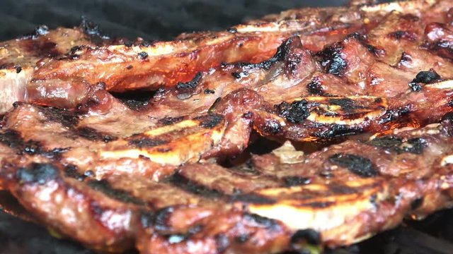 Char-grilled Marinated BBQ Korean Short Ribs on a barbecue grill with open flames.