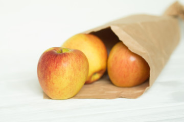 fresh ripe apples in a paper package on a white backgroung