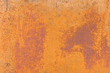 Textured background of a faded yellow paint with rusted cracks on rusted metal. Grunge texture of an old cracked metal surface. Rusty yellow-red stains