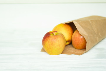 fresh ripe apples in a paper package on a white backgroung