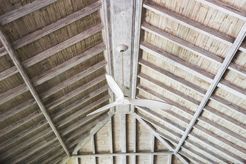 White ceiling fan under wooden roof, tropical house interior