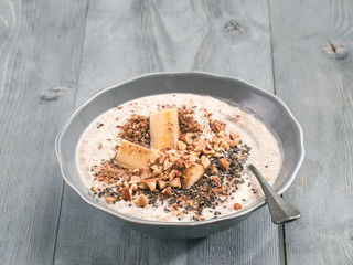 Overnight oats in bowl and ingredients on gray wooden table