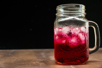 A glass of ice red water on the table