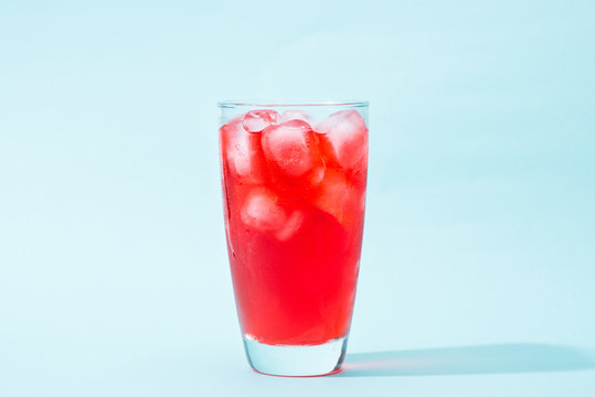 Soda. Red sparkling water with ice in a glass