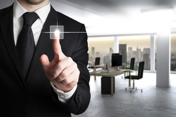 businessman in suit pushing button in modern it office