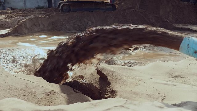 Close-up on pipe discharging of dredged river sand to disposal site