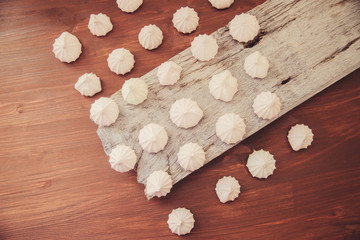 lots of little meringues on dark wooden background